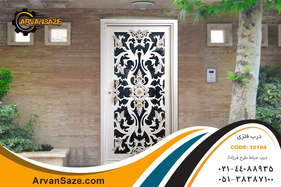 درب حیاط فلزی سفید رنگ با قطعات تزئینی برنجی رنگ، نصب شده بر روی ساختمان با نمای سنگ روشن